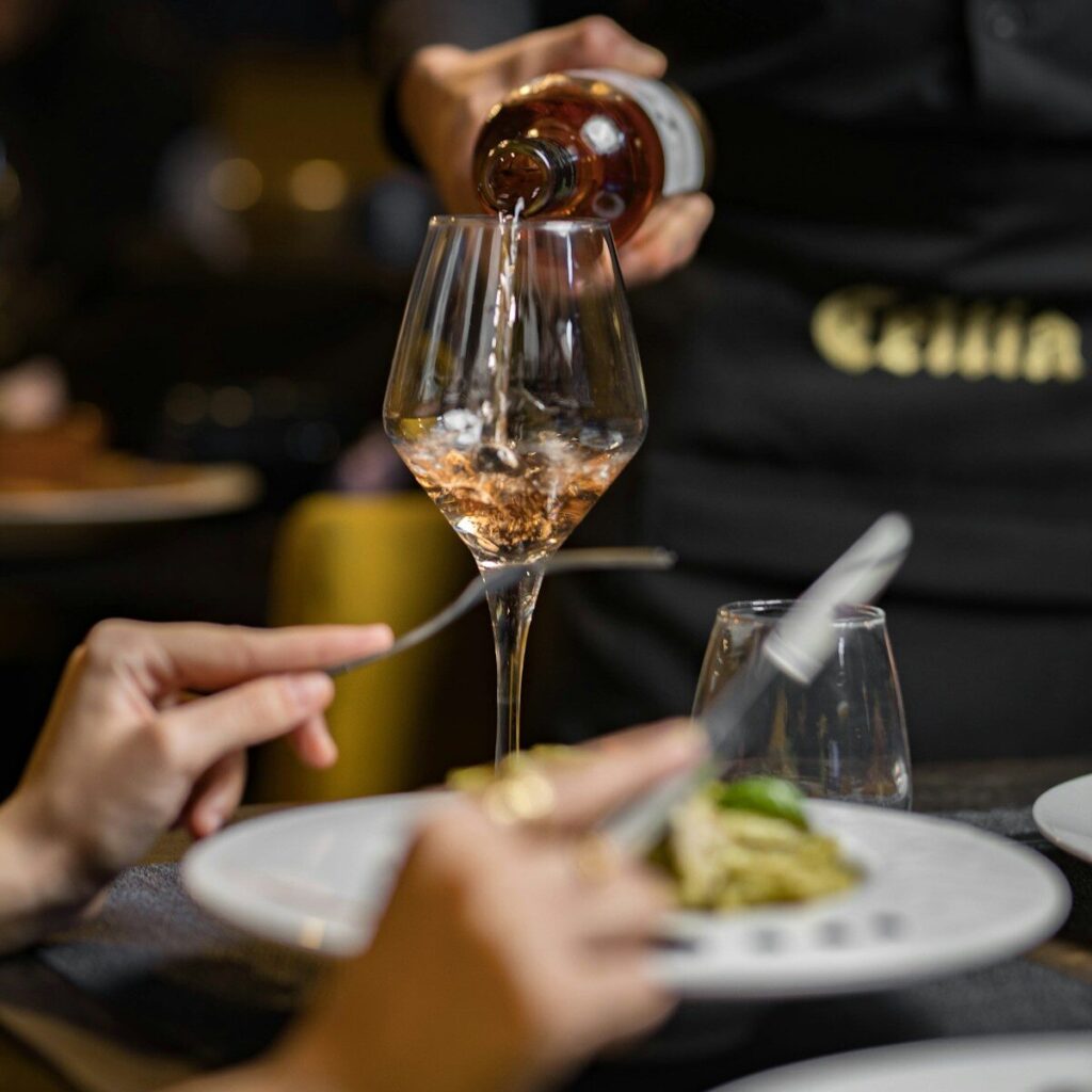 A person pouring wine into a wine glass